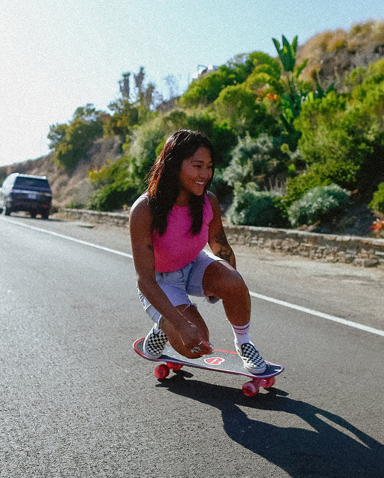 girl skating down the street on an Impala skateboard