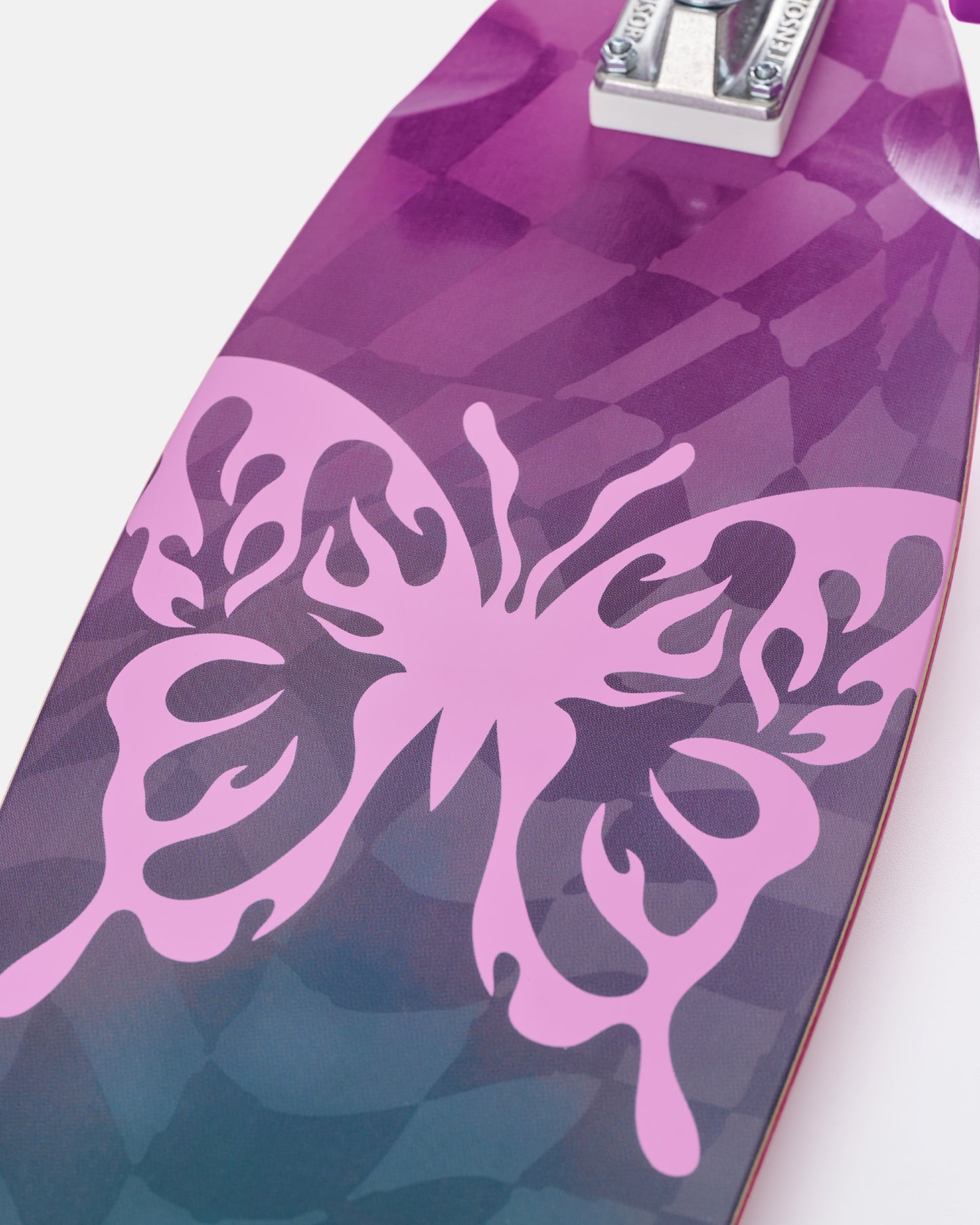 Close up of Impala Zeina Longboard deck in purple pink camouflage with bamboo top and clear grip tape