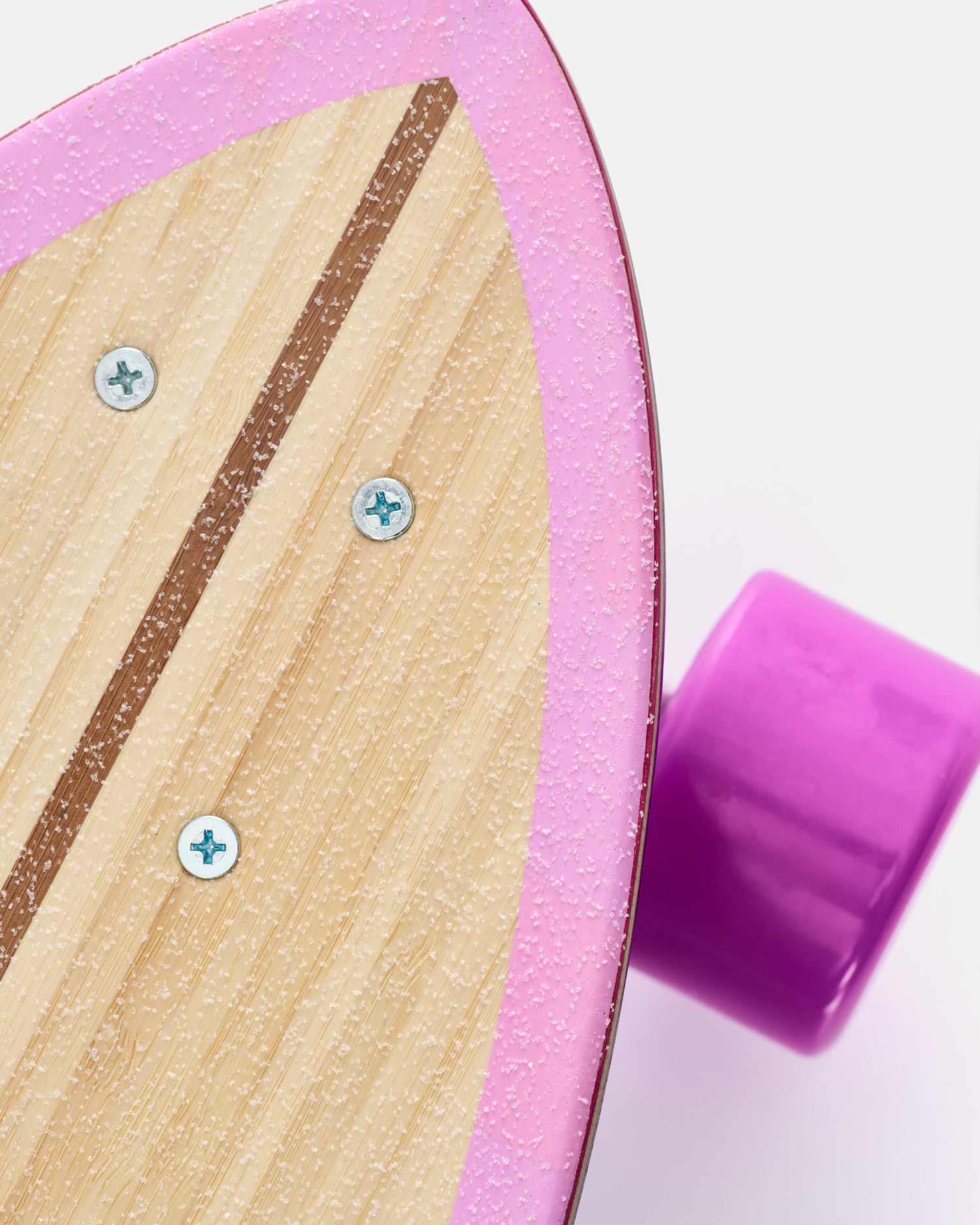 Pink Impala wheel close up with deck edge and top art partially visible on bamboo longboard