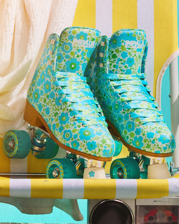 Two Impala Quad Skates in Ditsy Blue floral print displayed together with laces visible.