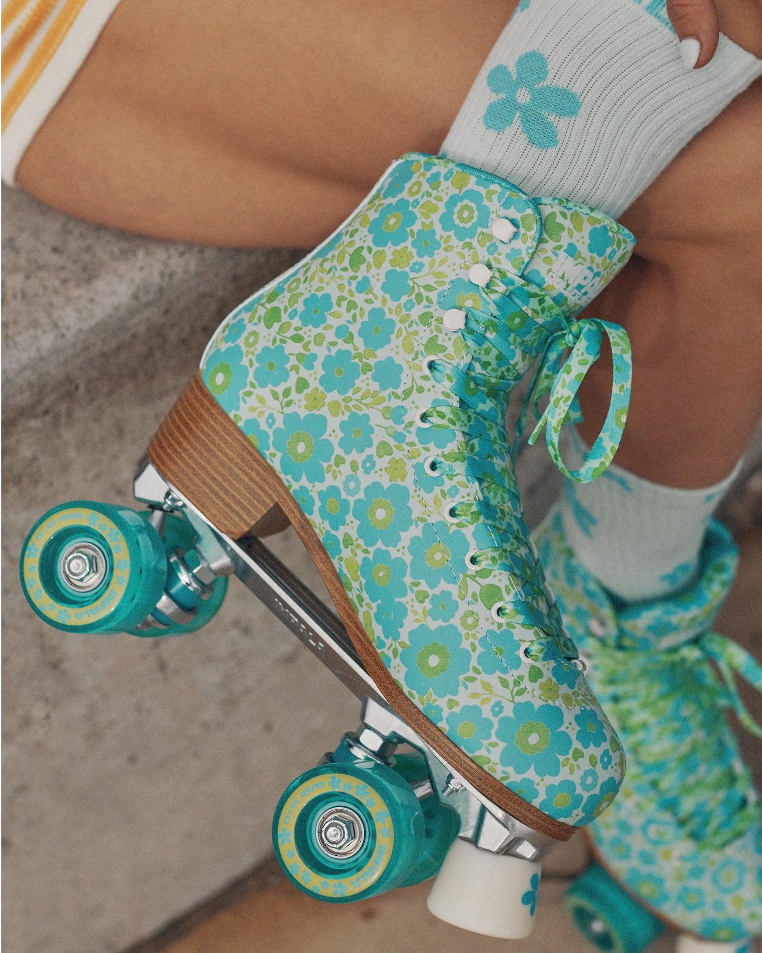 Person wearing floral-patterned roller skates on a concrete surface