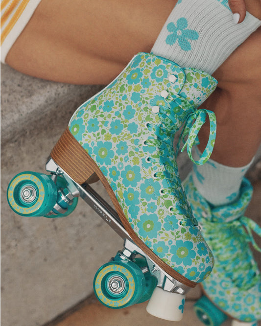 Person wearing floral-patterned roller skates on a concrete surface
