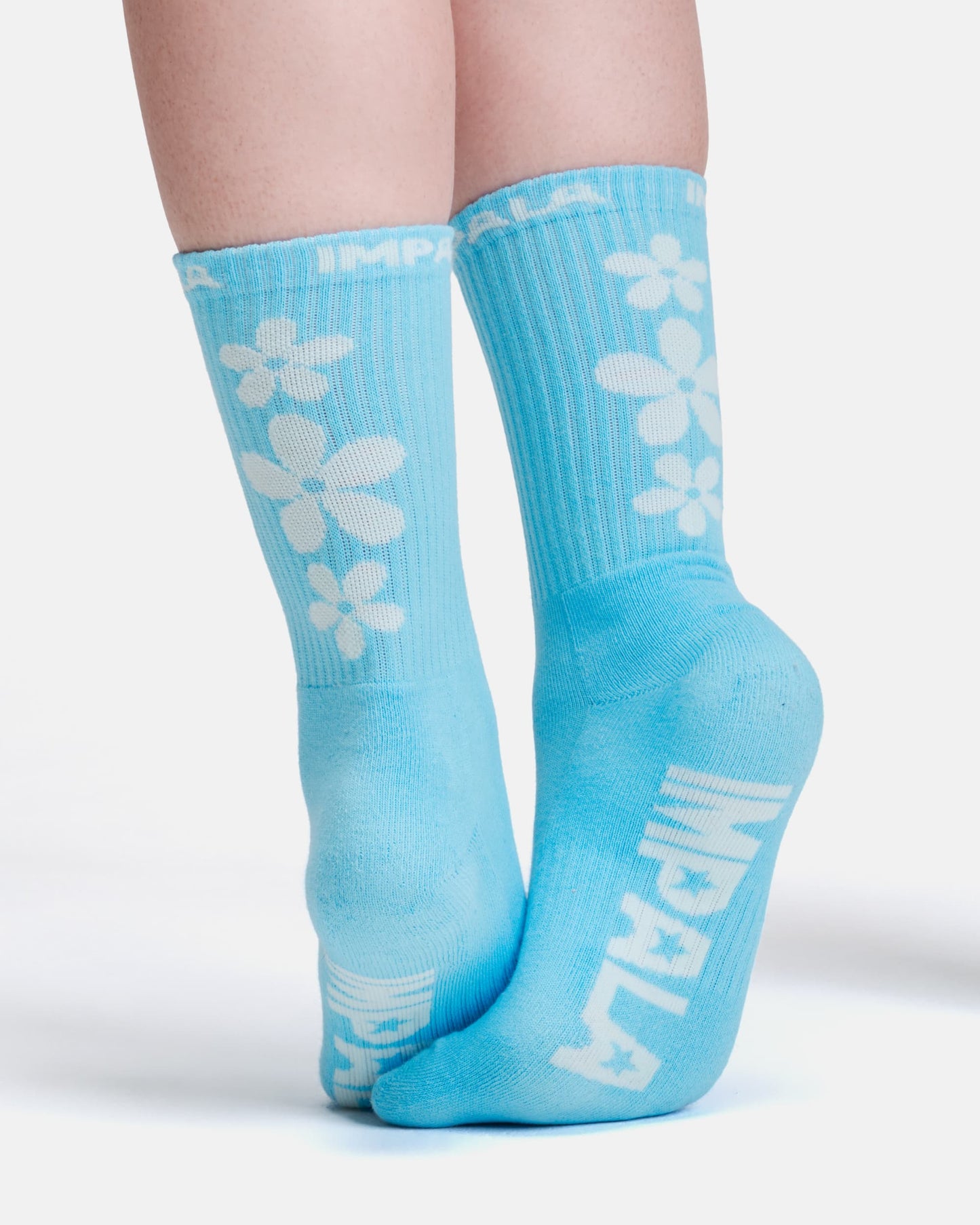 Light blue socks with white floral designs and branding on a white background