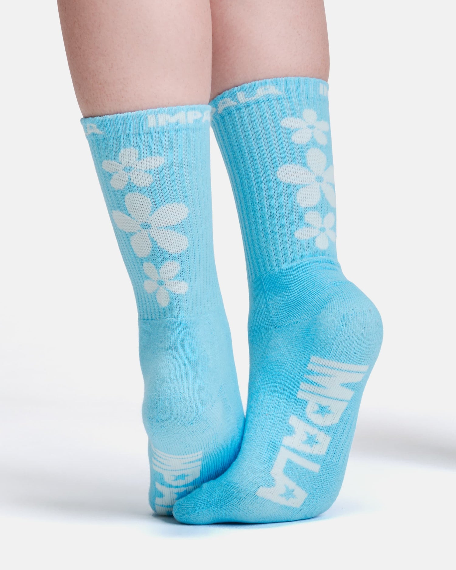 Light blue socks with white floral designs and branding on a white background